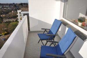 2 sillas azules en un balcón con vistas en Ferienwohnung Weitblick en Velbert
