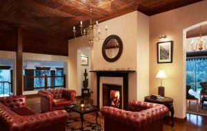 a living room filled with furniture and a fireplace at Jetwing St Andrew's in Nuwara Eliya