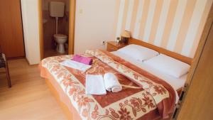 a hotel room with a bed with towels on it at Apartments & Rooms CASA GAGRO in Međugorje