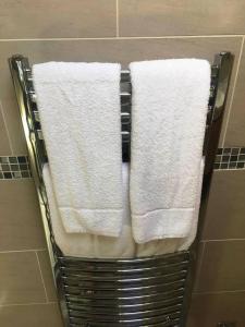 a towel rack with white towels in a bathroom at The Black Horse at Ireland in Shefford