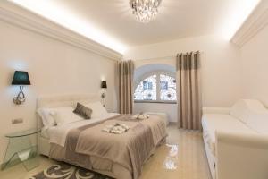 a white bedroom with a bed and a window at San Pietro Grand Suite in Rome