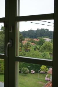 an open window with a view of a garden at Las Casinas de la Granda in Nueva de Llanes