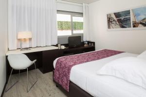 a bedroom with a bed and a desk with a computer at Royal Antibes - Luxury Hotel, Résidence, Beach & Spa in Antibes