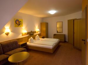 une chambre d'hôtel avec un lit et un canapé dans l'établissement Hotel Sonneck, à Schwäbisch Hall