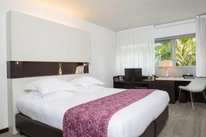 a bedroom with a large bed with a desk and a computer at Royal Antibes - Luxury Hotel, Résidence, Beach & Spa in Antibes