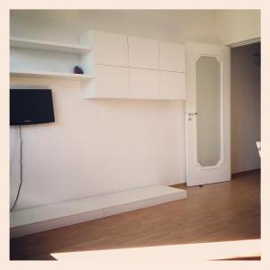 una stanza con pareti bianche, una porta e una televisione di roseto holidays a Roseto degli Abruzzi