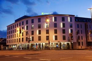 un gran edificio blanco en una calle de la ciudad por la noche en Holiday Inn Express - Siegen, an IHG Hotel en Siegen