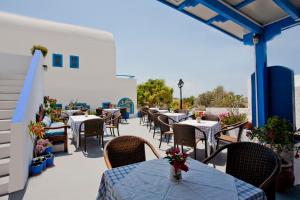 a row of tables and chairs on a patio at Ancient Thera Studios in Perissa