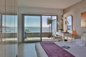 a bedroom with a bed and a view of the ocean at Royal Antibes - Luxury Hotel, Résidence, Beach & Spa in Antibes