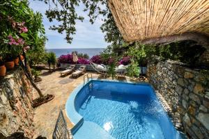 a swimming pool in a yard with a stone wall at Beyaz Yunus Hotel - Adult Only in Oludeniz