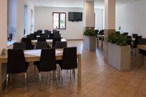uma sala de conferências com mesas e cadeiras e uma televisão de ecrã plano em Hotel Hubert em Slavonice