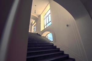 una escalera en un edificio con escaleras negras y una ventana en Gran Cancelliere B&B with Parking, en Palermo