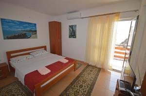 1 dormitorio con cama y ventana grande en Apartments Djakonovic, en Ulcinj