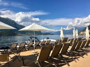 a row of chairs and umbrellas on a dock at Il Mulino di Hotel Villa Aurora in Nesso