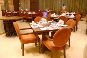 a dining room with tables and chairs with napkins at Cambay Grand Kukas in Jaipur