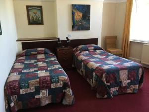 a hotel room with two beds and a window at The Bridge Inn in Isleworth