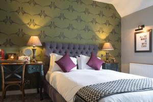 a bedroom with a large bed with purple pillows at The Townhouse in Stratford-upon-Avon