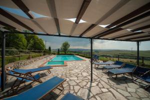a patio with chairs and a swimming pool at Agriturismo La Mirandola in Volterra