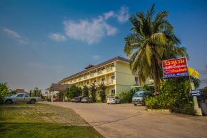 彭世洛Monrawee Pavilion Resort的一座建筑前有棕榈树的酒店