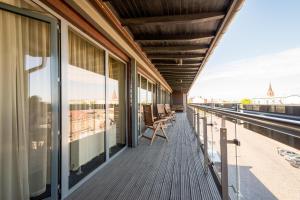 a balcony with chairs and a view of the city at Hotel Kolumbs in Liepāja