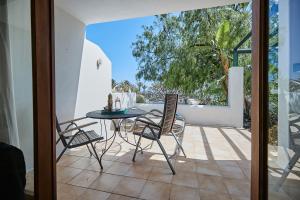 a balcony with a table and chairs on a patio at Villa Charco del Palo in Charco del Palo