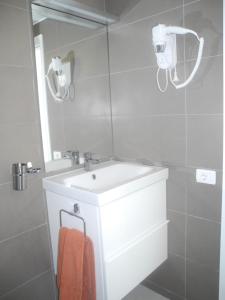 ein weißes Badezimmer mit Waschbecken und Spiegel in der Unterkunft Apartamentos Los Mocanes in Puerto Rico de Gran Canaria + 39 Fotos