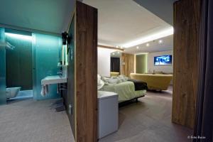 Un dormitorio con una cama y un baño con lavabo. en Hotel & Spa Ciudad de Binéfar, en Binéfar