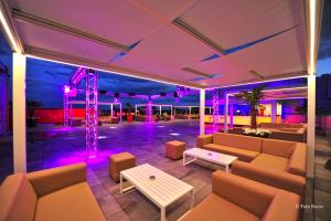 a room with couches and a stage with purple lights at Hotel & Spa Ciudad de Binéfar in Binéfar