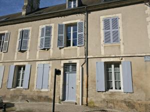 un antiguo edificio con persianas azules y una puerta blanca en La Maison d'Aristide - Les Univers de Panette - Jacques Cœur, en Bourges