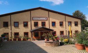 a large building with potted plants in front of it at Kornkäfer Kleinmockritz in Döbeln