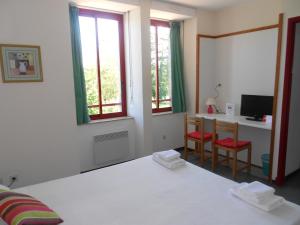1 dormitorio con 1 cama, 2 sillas y escritorio en Résidence du Rougier en Camarès
