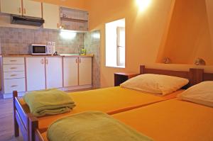 two beds in a small room with a kitchen at apartman željana in Vis