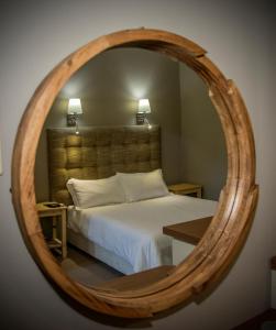 una camera con un letto e un grande specchio in legno di Gariep Country Lodge a Prieska
