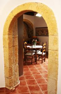 a dining room with a table and chairs and an archway at Fudulis Villa in Ravdhoúkha