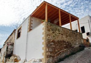 una casa construida sobre una pared de piedra en Fudulis Villa, en Ravdhoúkha