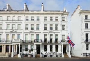 a large white building with a flag on top of it at The Pelham London - Starhotels Collezione in London