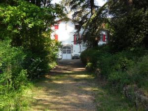 a path leading to a white house with red shutters at Chambres d'hôtes - B&B in Gétigné