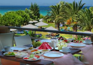 クシャダスにあるEphesia Hotel - All Inclusiveのビーチ付きのバルコニーにテーブルと食べ物