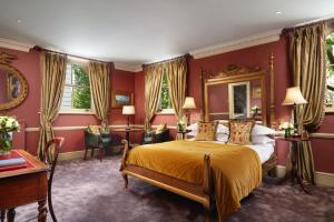 una camera da letto con pareti rosse e un letto con copriletto giallo di The Gore London - Starhotels Collezione a Londra