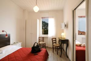 a hotel room with a bed and a table and chairs at Hotel Tirreno in Alassio