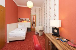 a bedroom with a bed and a desk with a chair at Stadthotel Hauser Eck in Sankt Pölten