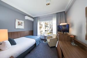 ロッテルダムにあるビルダーバーグ パークホテル ロッテルダムのベッドとテレビが備わるホテルルームです。