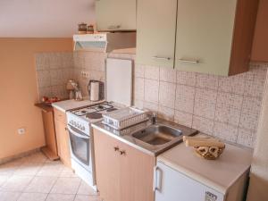 cocina con fregadero y fogones horno superior en Apartment Pletikosic, en Kaštela