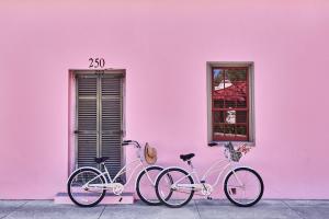 twee fietsen geparkeerd naast een roze muur bij The Collector Inn (Adults Only) - Saint Augustine in St. Augustine