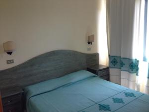 a bedroom with a large bed and two night stands at Residence Marina Palace in Orosei