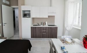 得利雅斯特的住宿－DOMO Apartments - Trieste Goldoni，小厨房配有白色橱柜和水槽