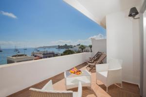 a balcony with chairs and a table with fruit on it at Akkan Hotel in Bodrum City