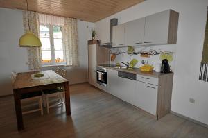 eine Küche mit einem Tisch und einem Herd Top-Backofen in der Unterkunft Apartements Wallner in Hallstatt