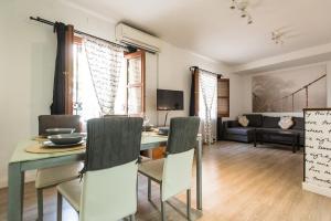 a dining room and living room with a table and chairs at Apartamento Centro Sevilla in Seville