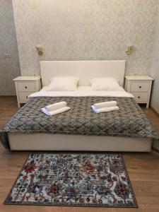 モスクワにあるHotel Compasのベッド1台(白い枕2つ、ラグ付)